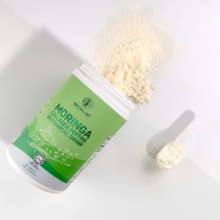 Moringa supplement container with a spoon on a white background